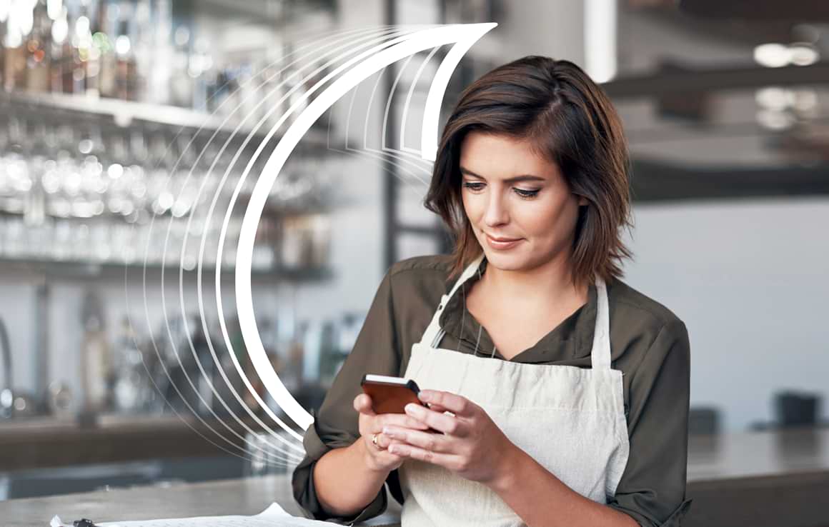 Female barista using smartphone
