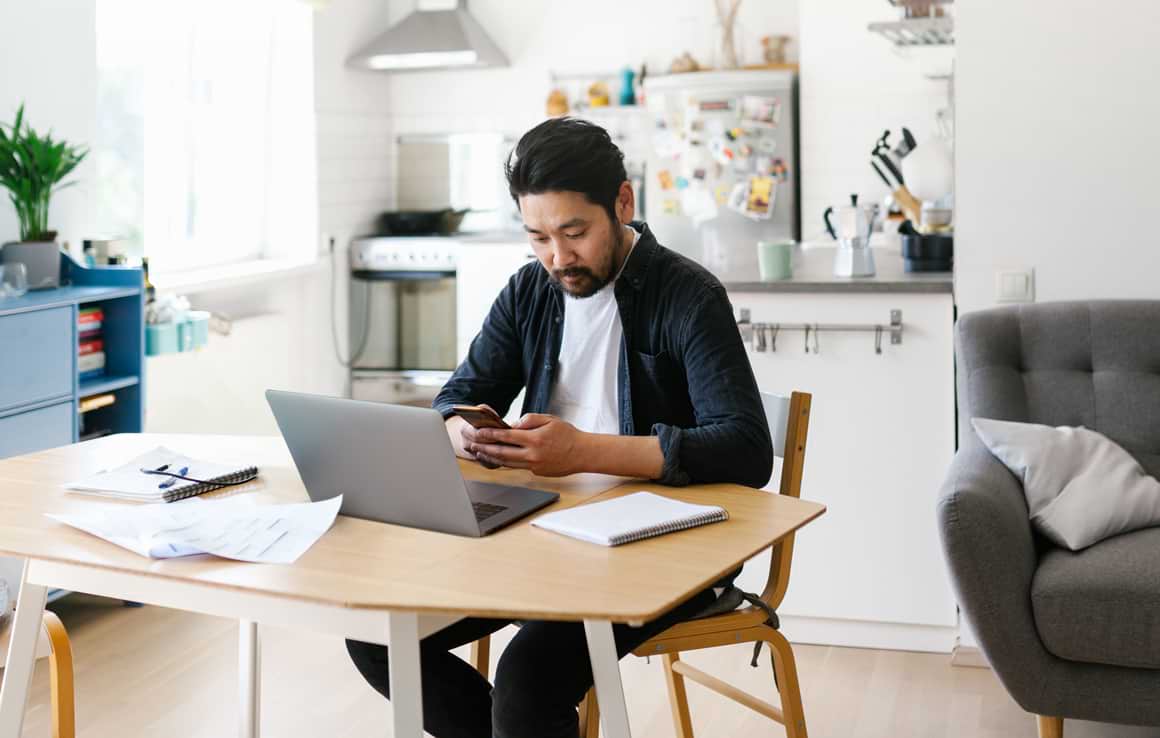 Man working on laptop in home kitchen