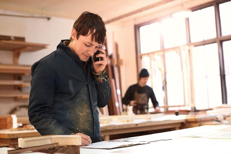 Carpentar taking a phone call at work