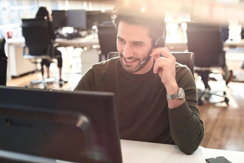 Man on computer with headset