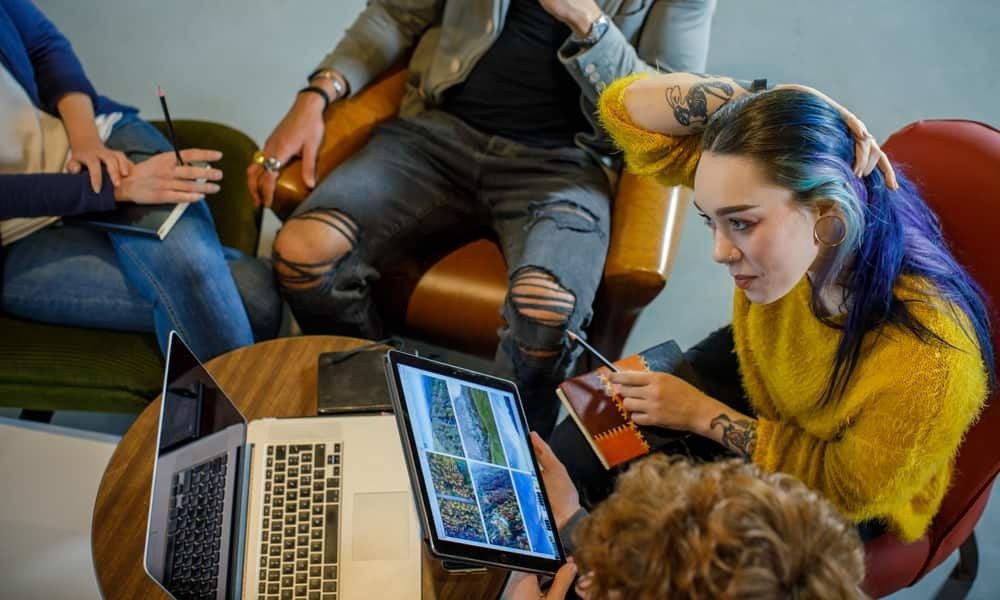 Employees working together on laptop and tablet from cafe