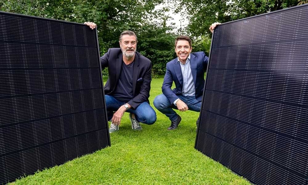 Kevin Maughan, Urban Volt, and Colin Barrett, Vodafone, pose with large solar panels in a park.