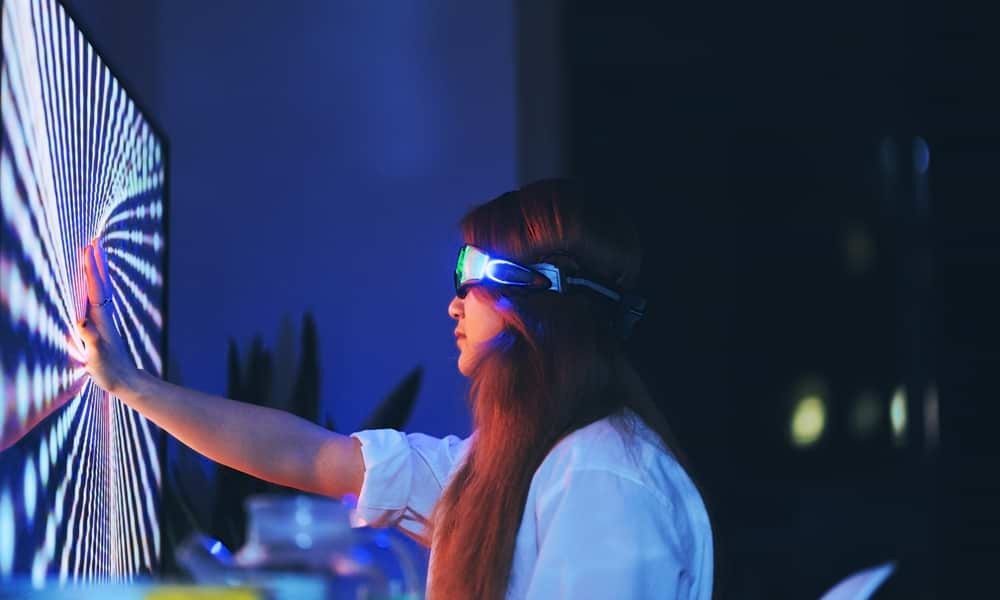 Woman wearing VR headset with hand on screen
