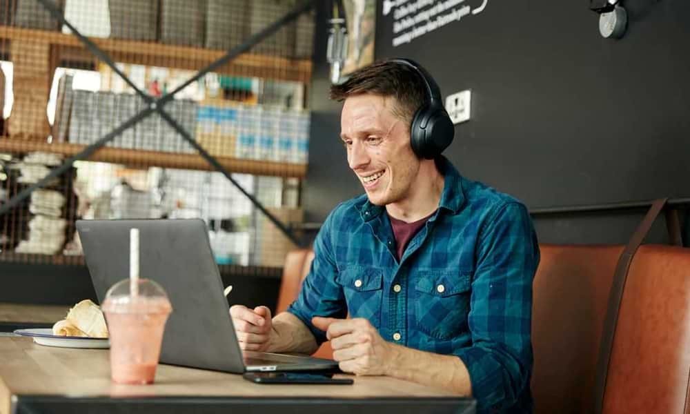 Man talking on laptop in cafe